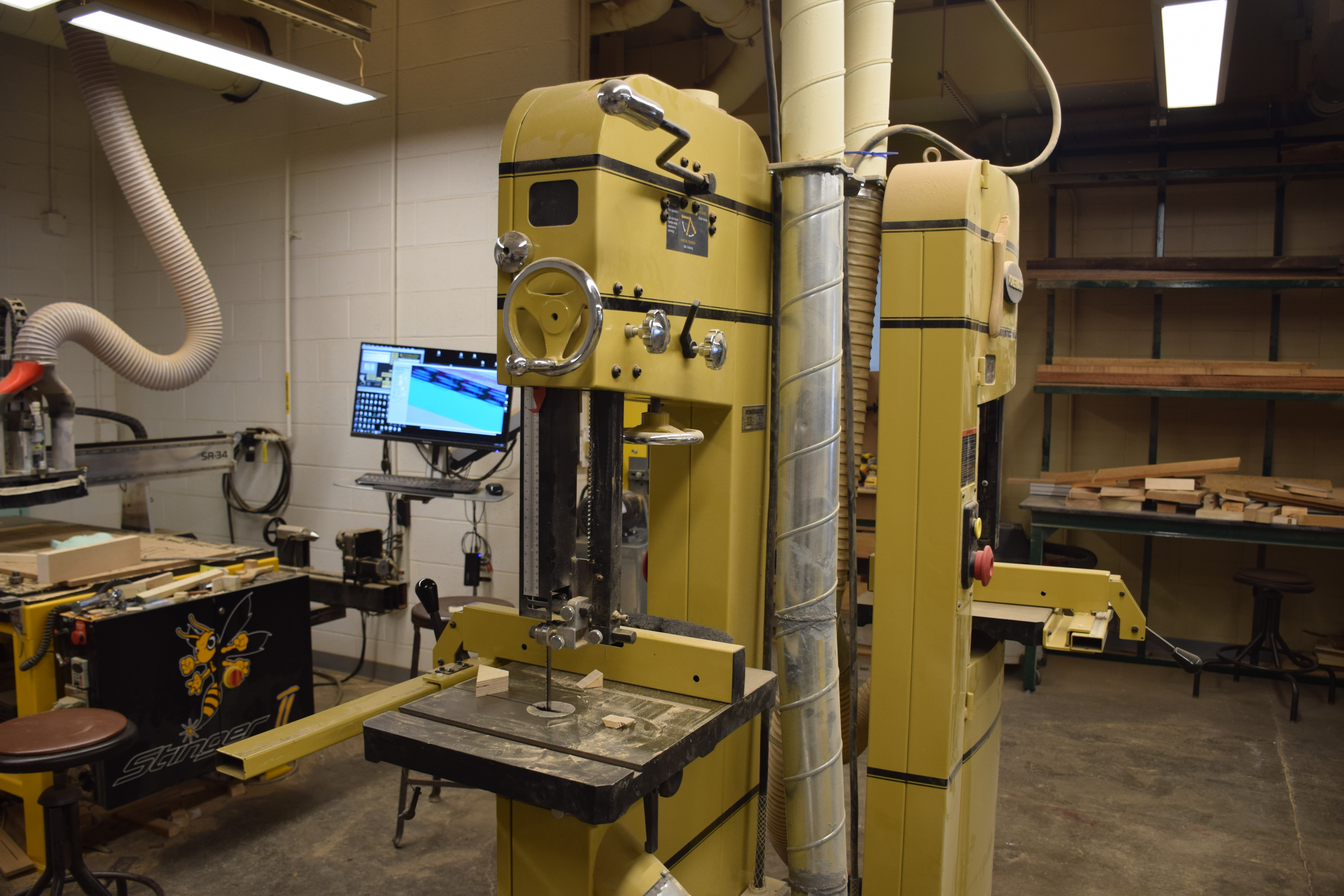 Two Bandsaws with backs against a pole